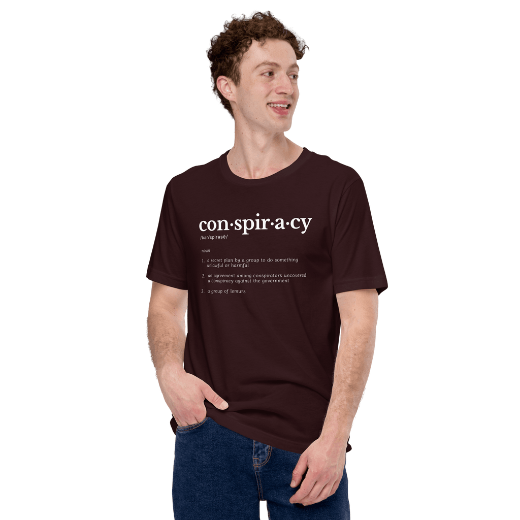 Conspiracy definition T-shirt worn by a person, oxblood with con·spir·a·cy dictionary text